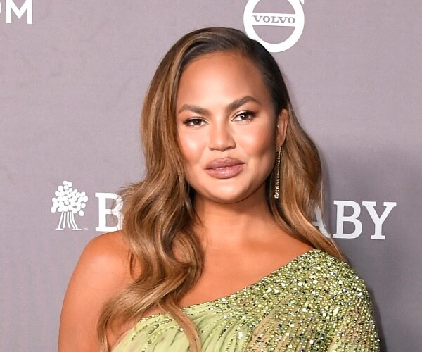 chrissy teigen stands on red carpet