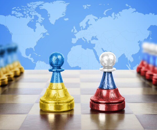 chess pieces with ukraine and russian flags in front of a world map