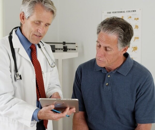 Doctor reviewing study results with man in office