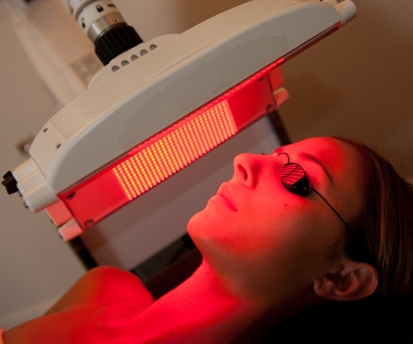 woman under a light undergoing phototherapy