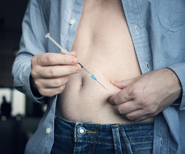 man giving himself injection of Ozempic