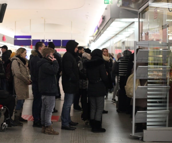 People standing in front of the information center in the train station