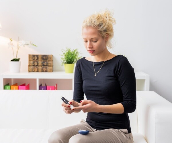 woman with diabetes at home checking her blood glucose