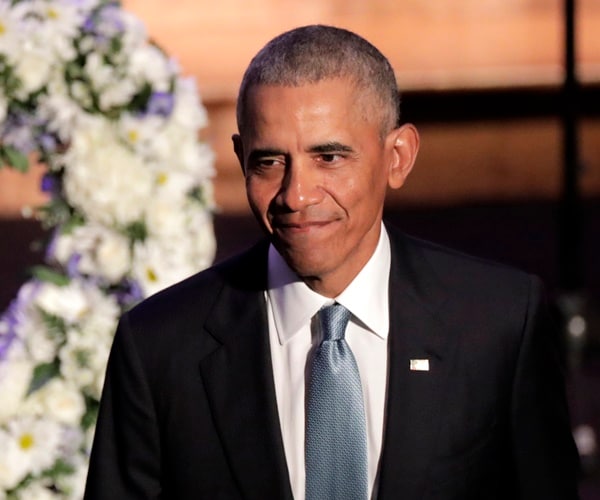 barack obama walks off stage in front a a hear floral bouquet