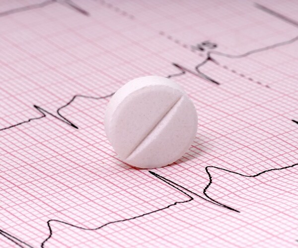 a pill on a heart EKG