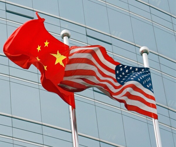 A U.S. and a Chinese flag wave outside a commercial building in Beijing