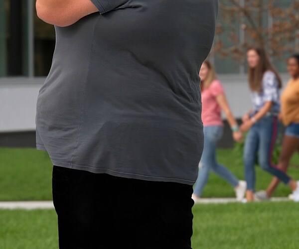 obese man stands outside