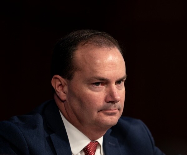 mike lee sits behind bench