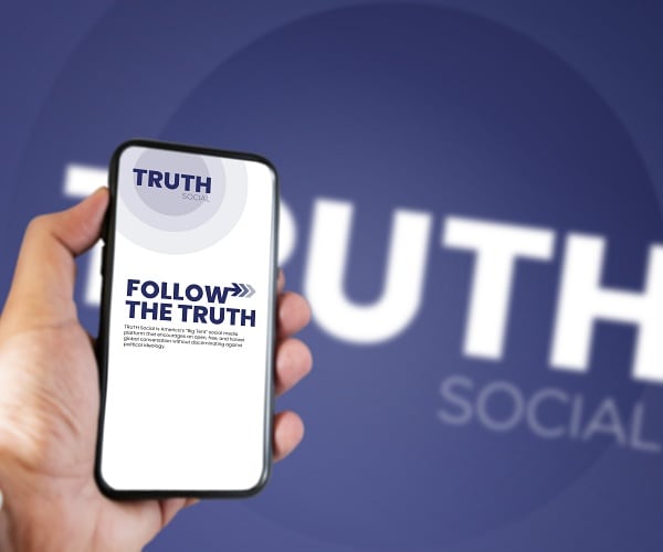 hand holding phone showing truth social mobile app on screen