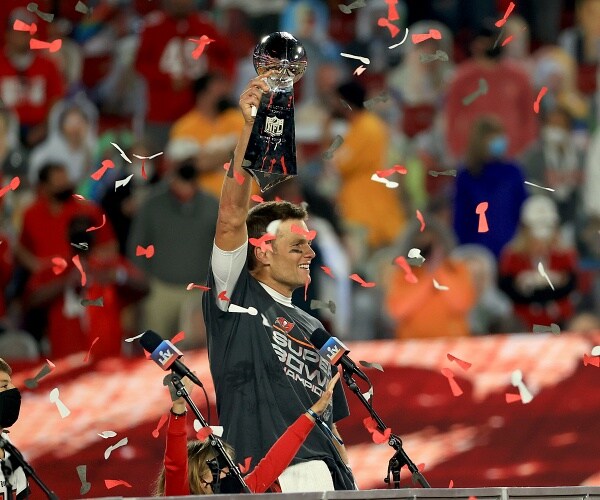 tom brady holds trophy over his head