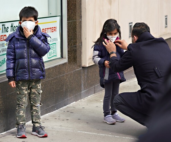 a man puts a protective mask over his children's face