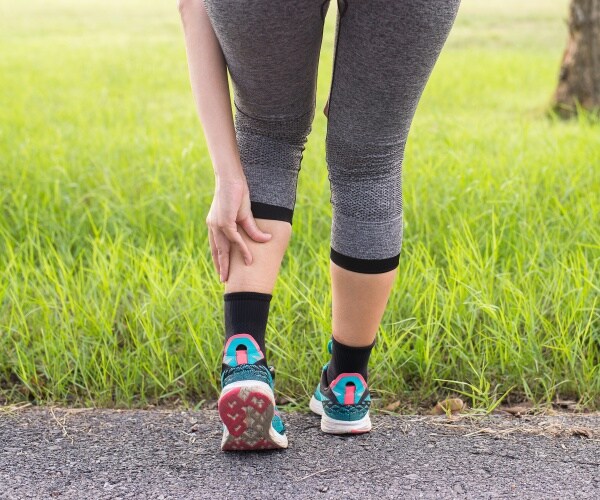 woman grabbing calf because of painful charley horse