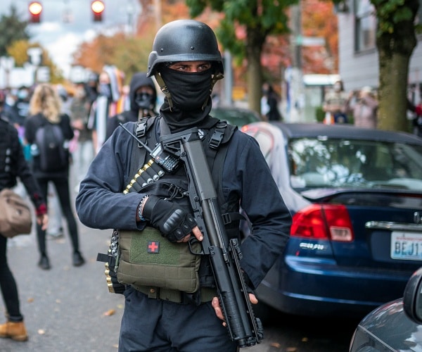 armed protester stands outside county election office