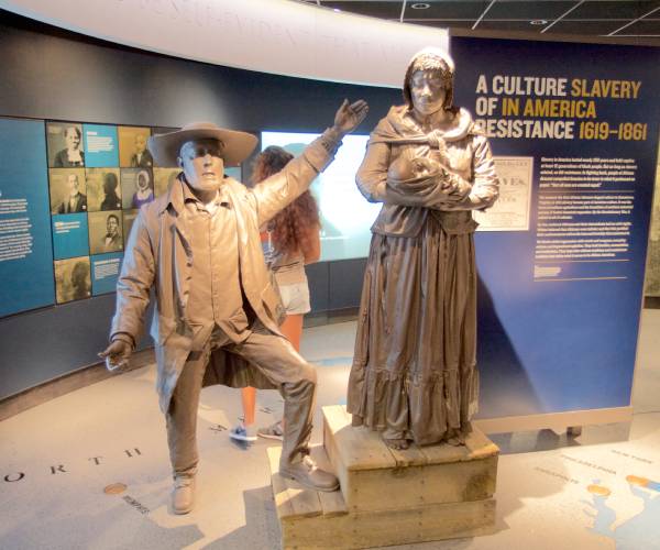 statues in a museum of female slave and a slave trader