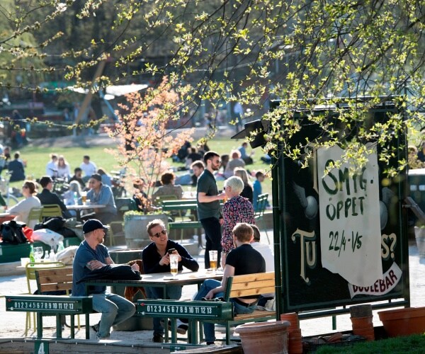 people talk outside in spring without masks in sweden