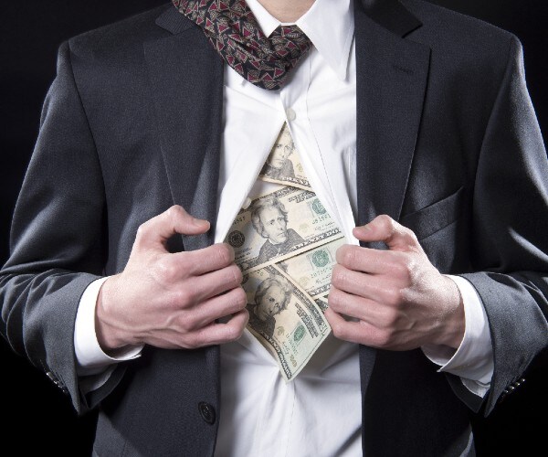 man in suit opening shirt and showing he is made out of money