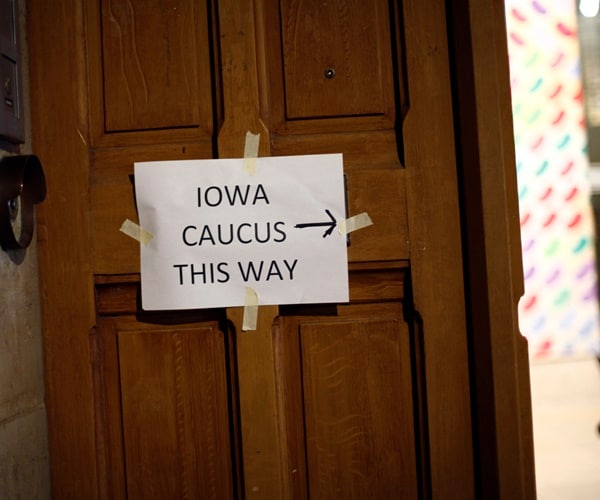 a sign directs caucus goers to an iowa caucus event