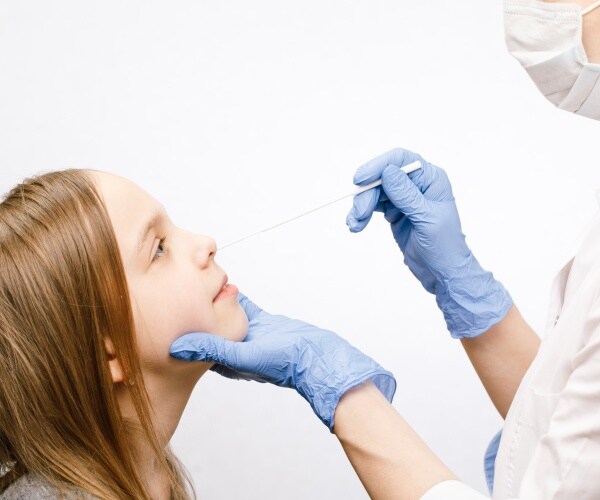 doctor using a nasal swab on a child for sample