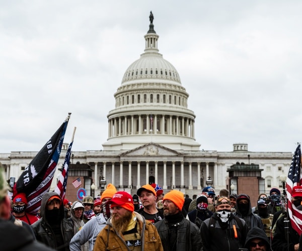 protesters wear trump gear and carry flags outside the capitol