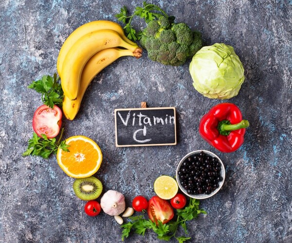 small chalkboard says 'vitamin c' surrounded by vitamin C-rich foods in a circle