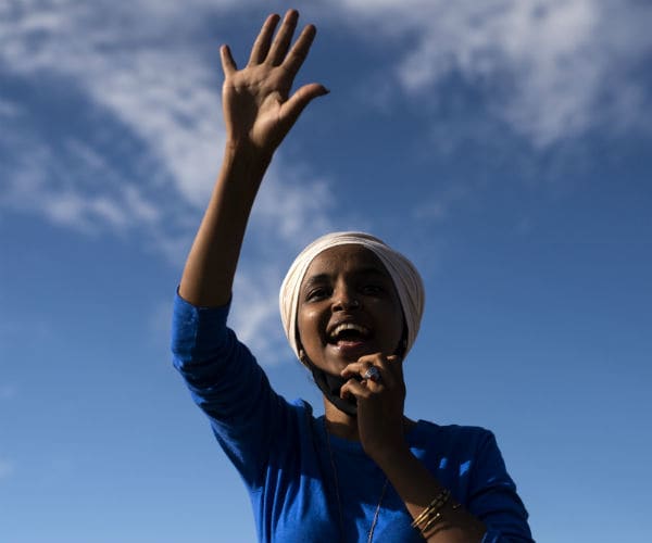 rep. ilhan omar is seen in a blue blouse and white turban on her head