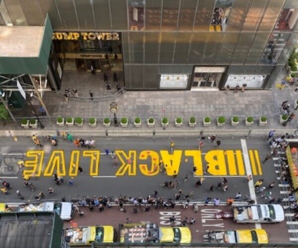 trump tower building with black lives matter painted in yellow on the road