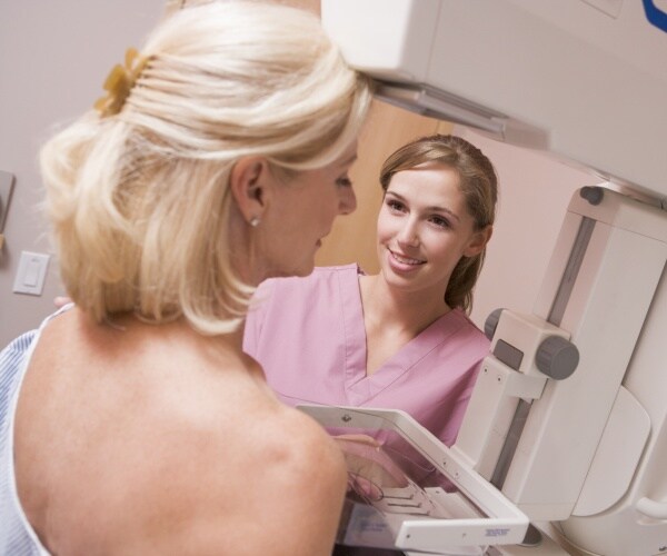 woman undergoing mammogram and a technician in room