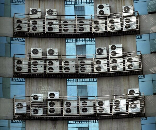 Air conditioners hang on the wall of an office building 