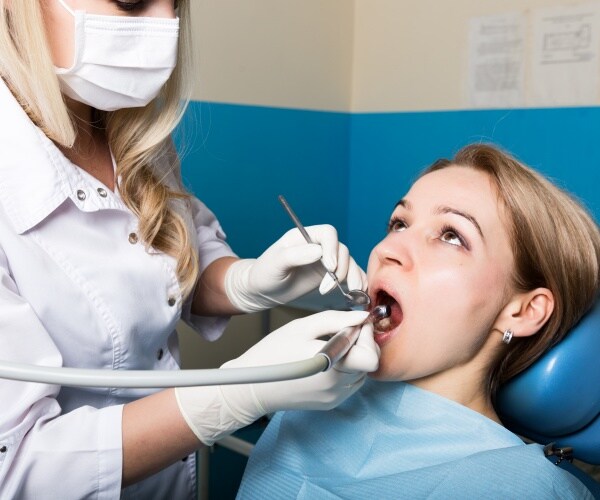 dentist examining a woman's teeth