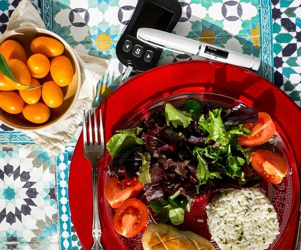 healthy food with blood glucose monitor on table