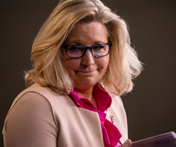 liz cheney smirks and turns during a news conference