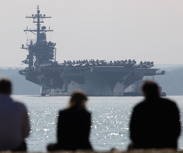 the uss roosevelt sails as people watch