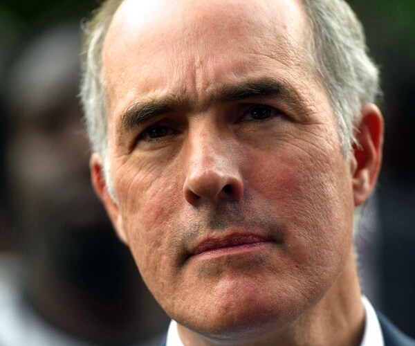 senator bob casey of pennsylvania listens to former president barack obama speak during a campaign rally in 2018
