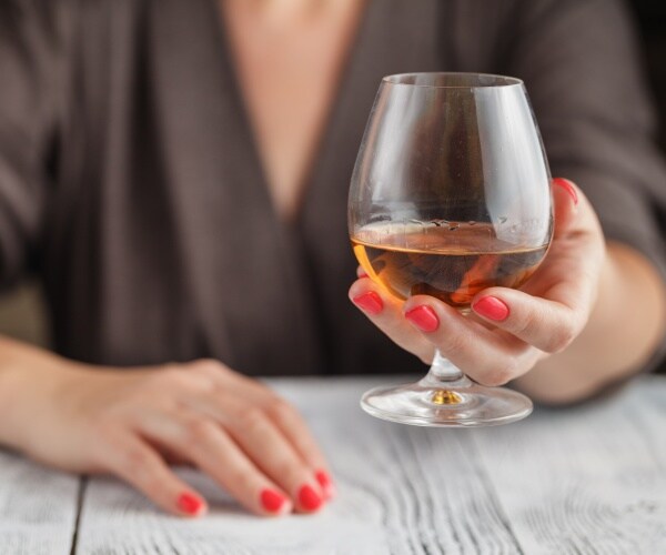 woman holding a full wine glass