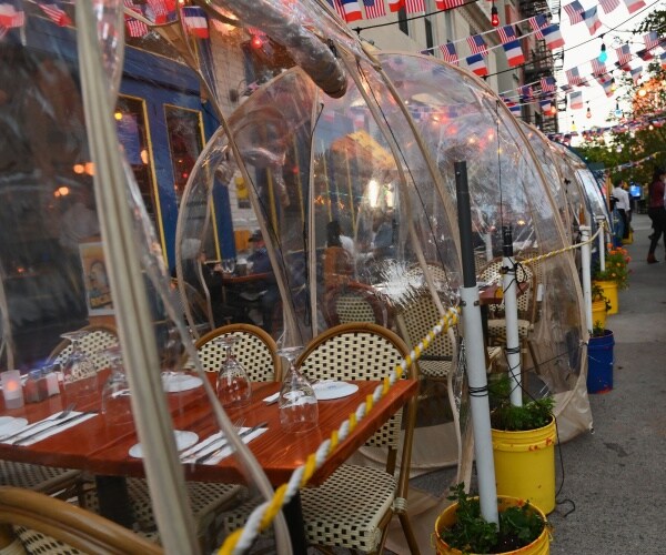 plastic restaurant tents set up outside 