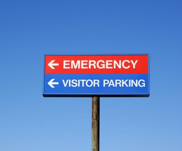 Sign that reads "Emergency. Visitor parking."