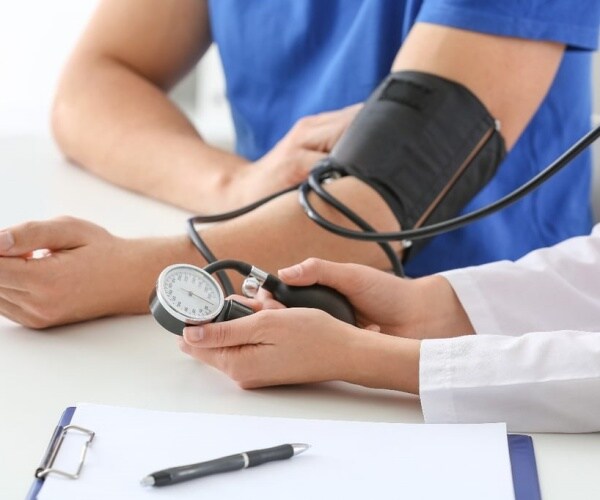 person having blood pressure checked in doctor's office