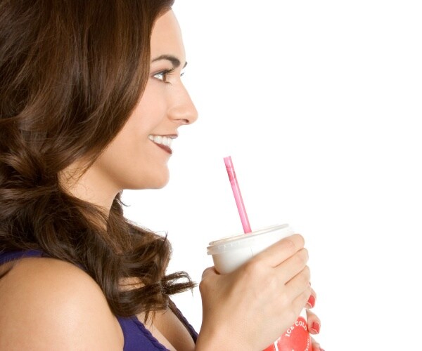 woman drinking a diet soda with a straw