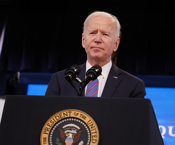 joe biden stands behind podium 