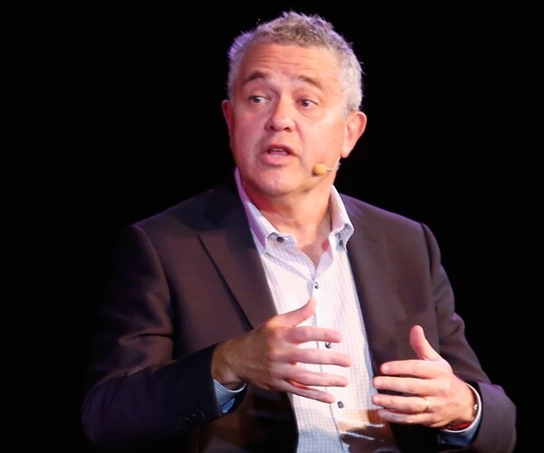 jeffrey toobin wears a headset and speaks on a stage