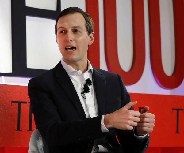 jared kushner is shown speaking in black and white suit with no tie