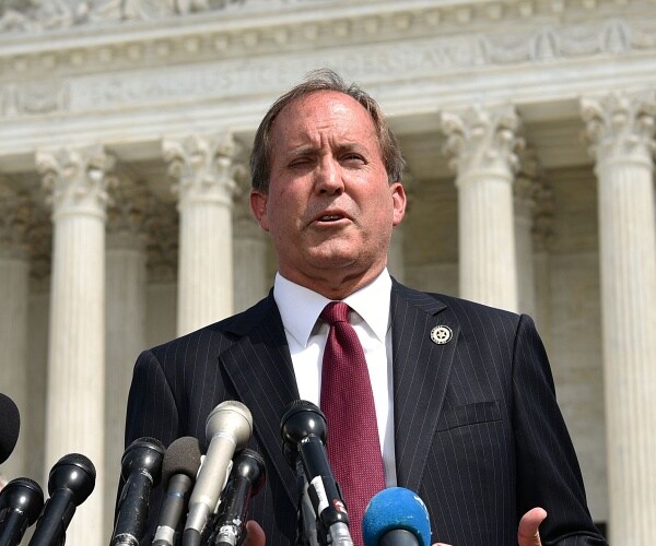 ken paxton speaks into mic outside supreme court