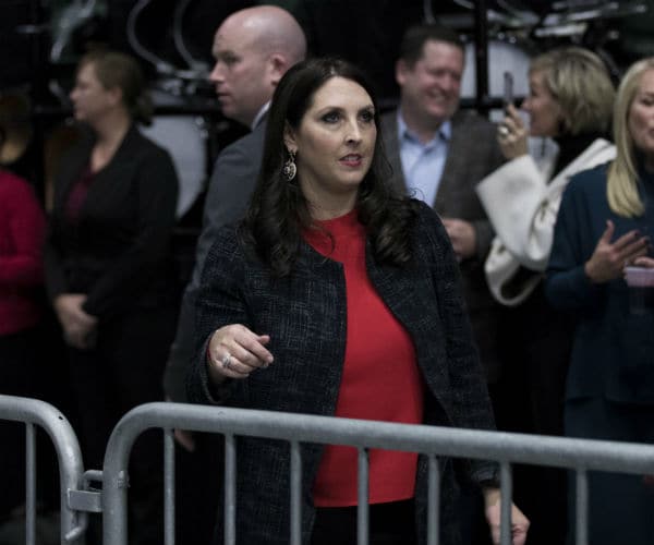 ronna mcdaniel is shown in a red blouse with a blue and white dress jacket