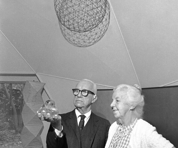 fuller holding a small geodesic dome and a woman standing beside him smiling