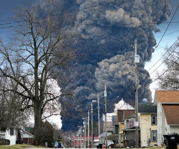 smoke rising behind a neighborhood street