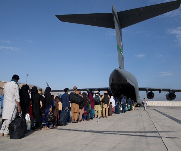 people stand in line to board jumbo jet