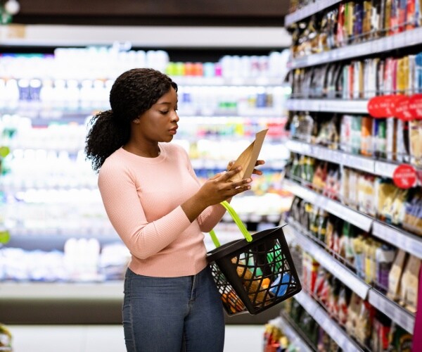 woman making choice of products at supermarket