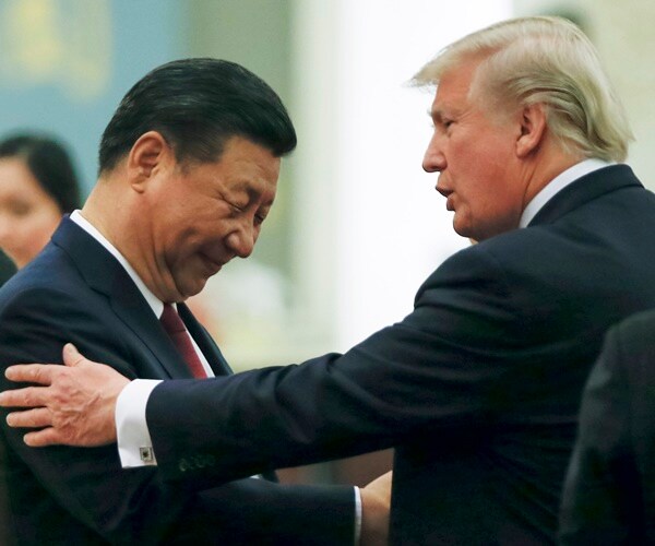 president donald trump speaks with president xi jinping, putting a hand on his arm