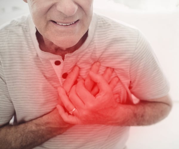 man clutching his chest due to pain is shown