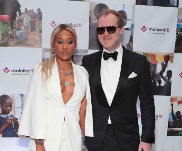 eve in a white outfit standing next to cooper in a black suit and bow tie wearing sunglasses